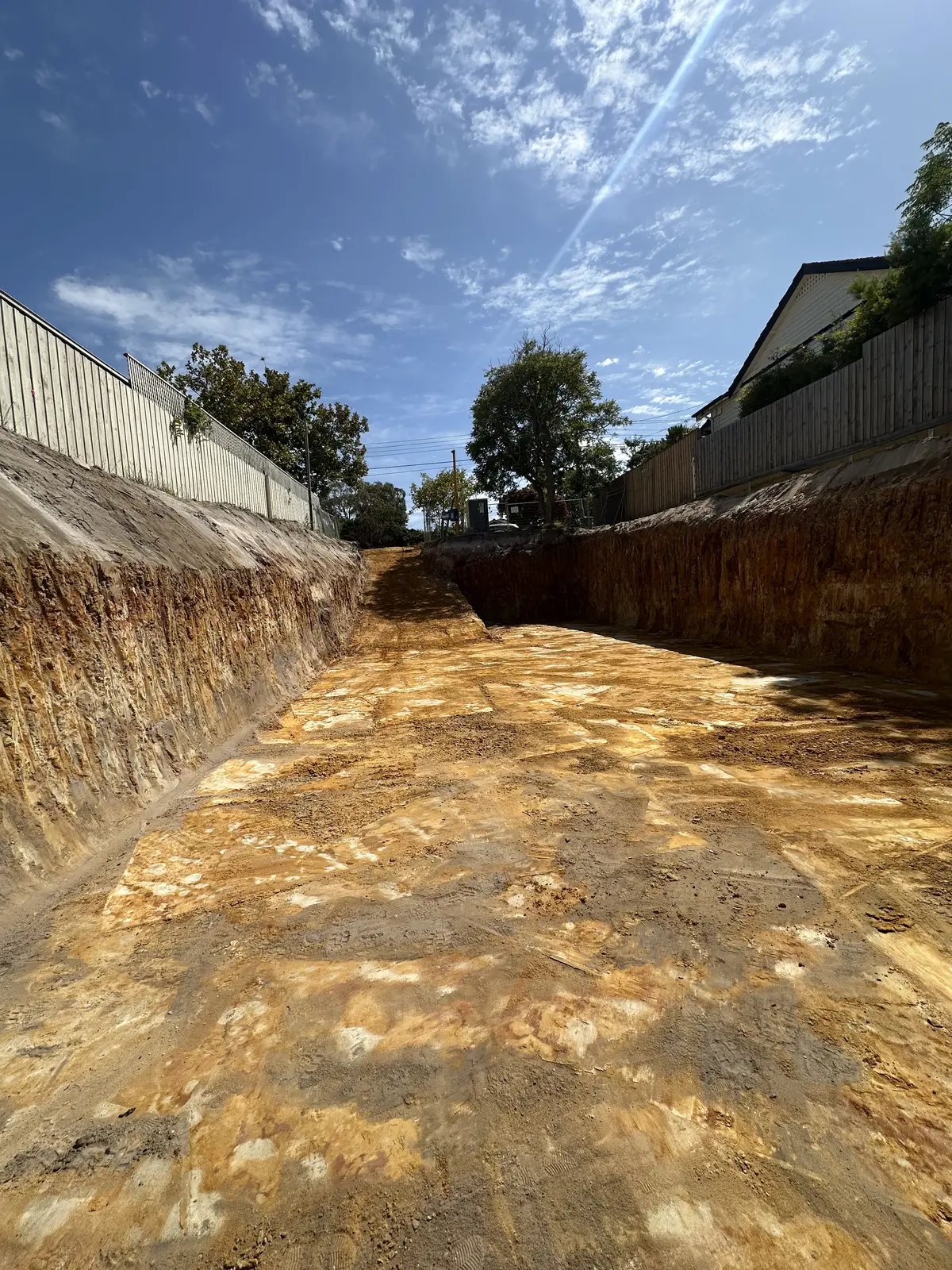 Entire Excavations cut earth bank beside a house during site works